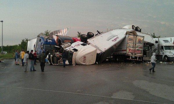 Semi-Trucks thrown like toys in the storm, piled on top one another.